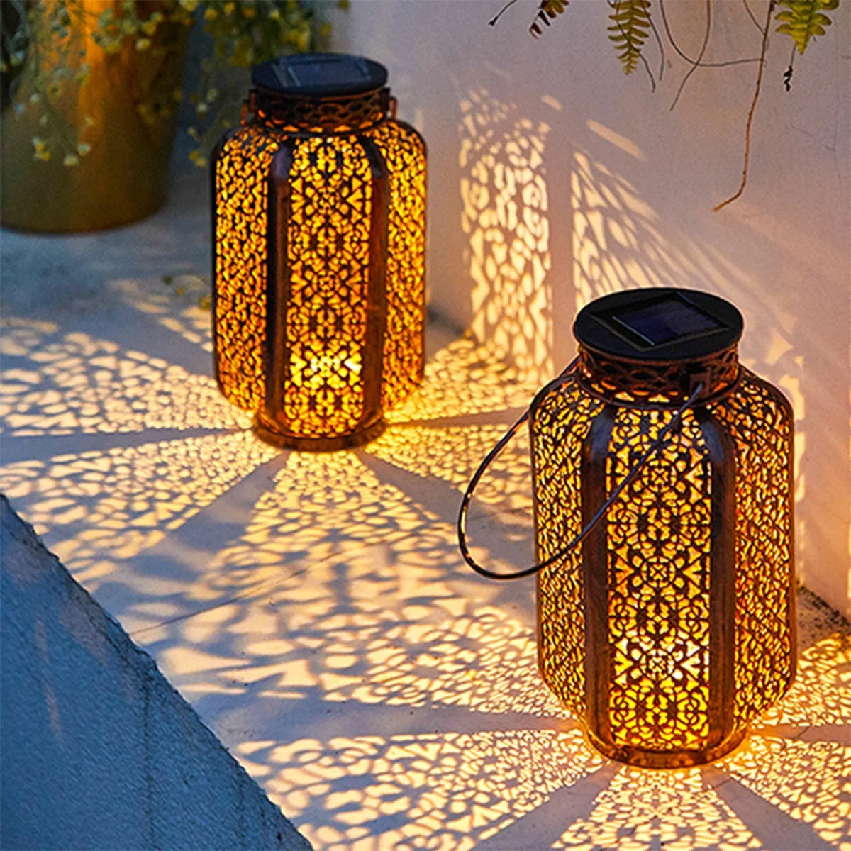 Cut-metal solar lanterns glowing in a garden at dusk