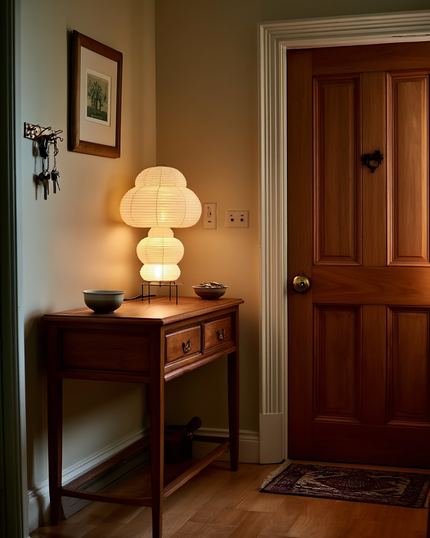 The Kumo tiered lamp on a hallway console with keys and a ceramic dish