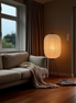 The Tomo floor lamp beside a sofa with a knit throw at dusk