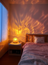 The Tide Lamp casting warm water ripple patterns across a bedroom wall at night