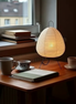 The Paper Lantern lamp on a desk with books and tea, afternoon window light