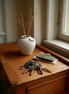 The Komo Vase with dried stems on an entry console beside keys, soft daylight