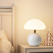 Bloom glass mushroom table lamp in cloud white glowing warm on a nightstand