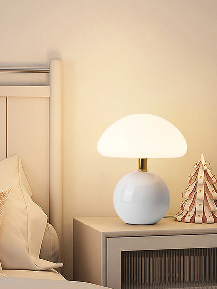 Bloom glass mushroom table lamp in cloud white glowing warm on a nightstand