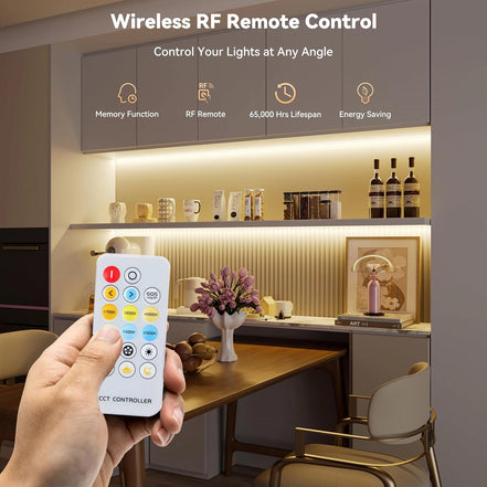 A hand holding the wireless remote in a kitchen lit by the COB strip under the cabinets