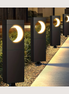 Solar pathway bollard lights glowing warm along a garden path at dusk