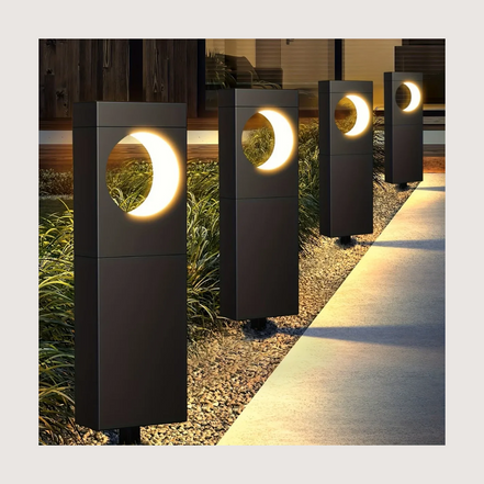 Solar pathway bollard lights glowing warm along a garden path at dusk